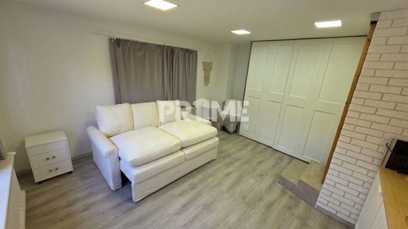 Living room in a family house with a white sofa and a floor with a wooden decor.