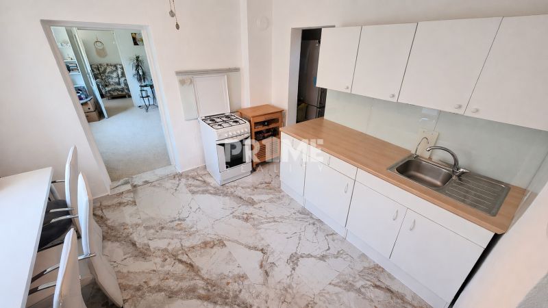 A kitchen in a family house with white cabinets and a gas stove.