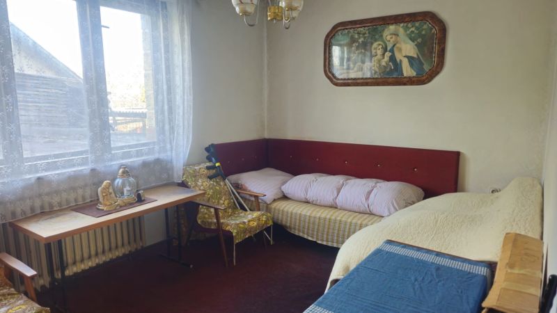 A room in a family house with retro furniture, decoration, and a view from the window.