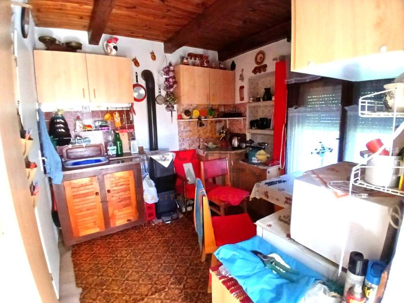 A kitchen with wooden decor, cabinets, and kitchen utensils on the wall in the Gardens.