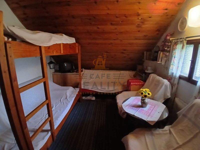 Attic room with curtains, bunk bed, and wooden decor in Gardens.