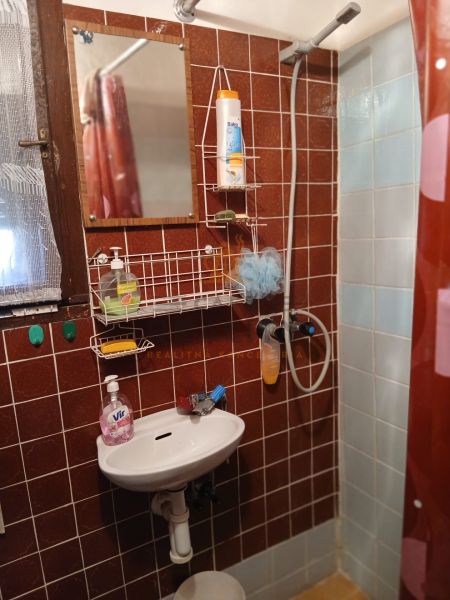 Bathroom with a mirror, sink, and shower, Gardens.