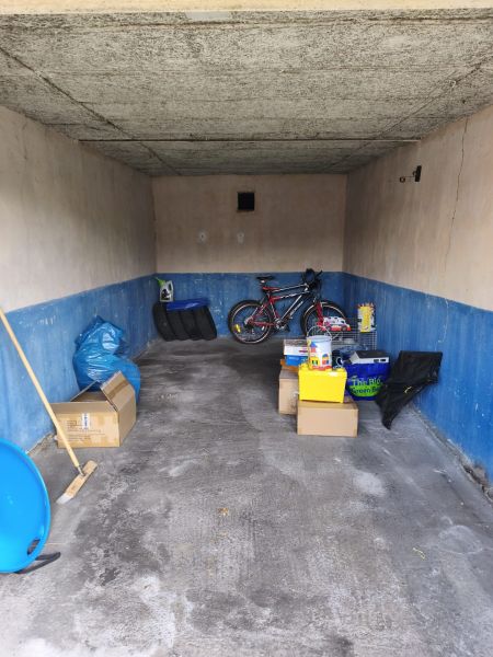 A garage in Prievidza on Dlhá Street with stored boxes and a bicycle.