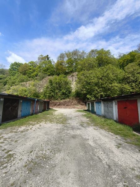 Parking garages on Dlhá Street in Prievidza surrounded by natural forests and the sky.
