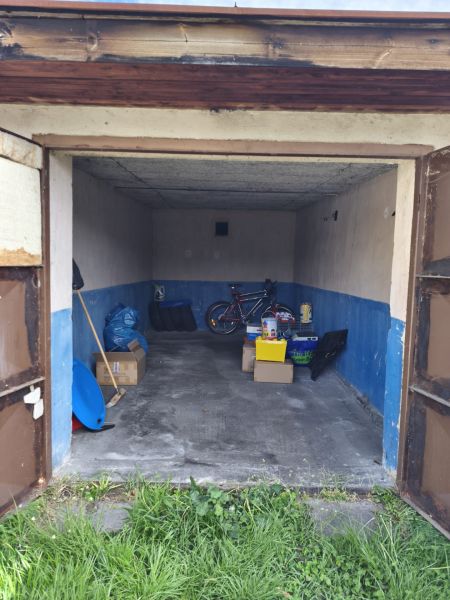 Garages on Dlha Street in Prievidza with a bicycle and various tools.