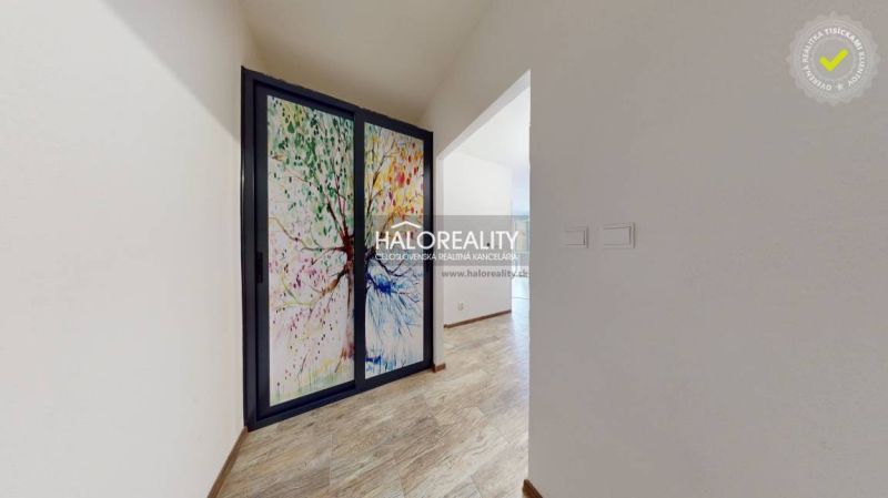 A hallway with sliding glass doors and a wooden decor floor in a studio apartment.