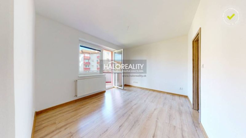 Studio apartment with wood-patterned flooring and a balcony, bright space.