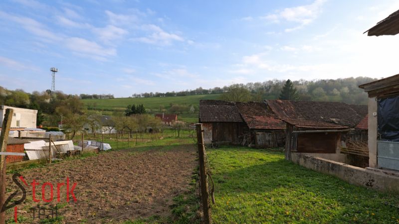 Older buildings and fields surrounded by nature in Horná Súča near the family house.