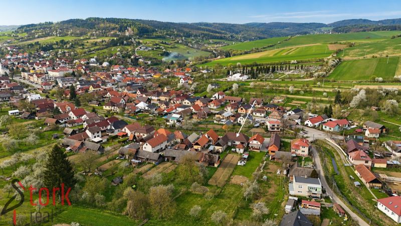 An aerial view of family houses in Horné Súčany surrounded by green fields and hills.