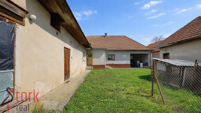 The yard of a family house in Horná Súča with a grassy area and farm buildings.