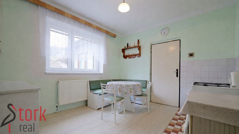 A kitchen in a family house with a corner bench, a white table, and chairs.