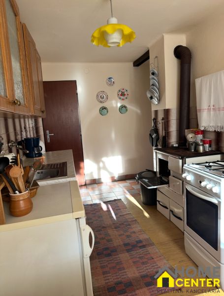 A kitchen in the Gardens with a yellow light fixture, an oven, and decorative plates on the wall.