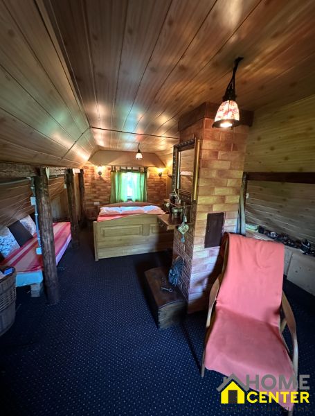 Attic room with a sofa, wooden ceiling, and brick wall in the Garden area.