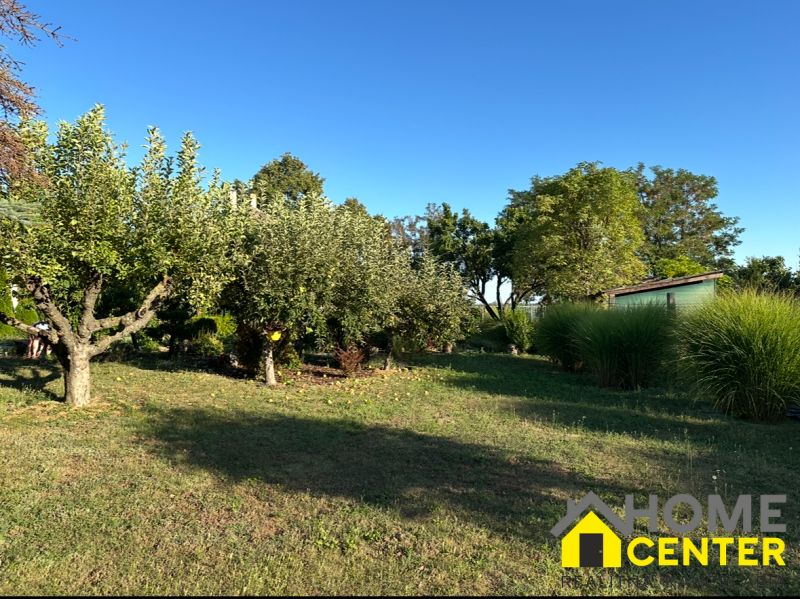 A garden in Chotín on Pri stanici street with fruit trees and a wooden house.