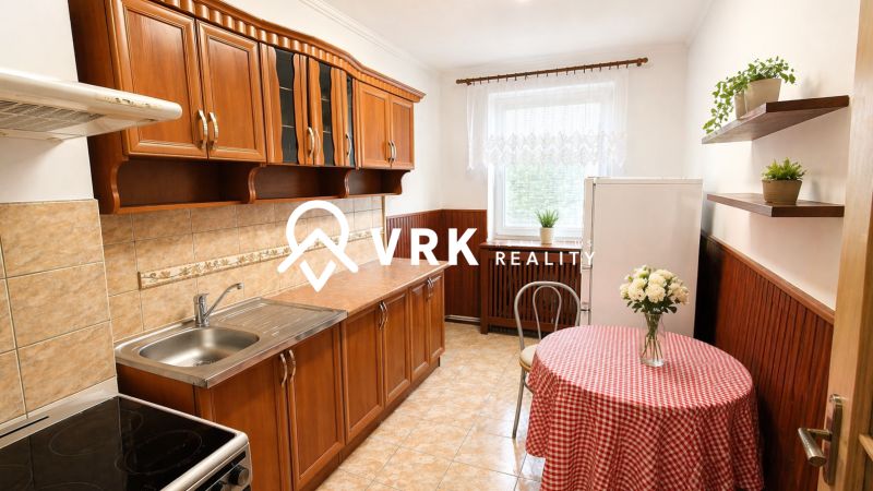 A kitchen in a 4-room apartment with wooden cabinets and tiles, complemented by a dining table.