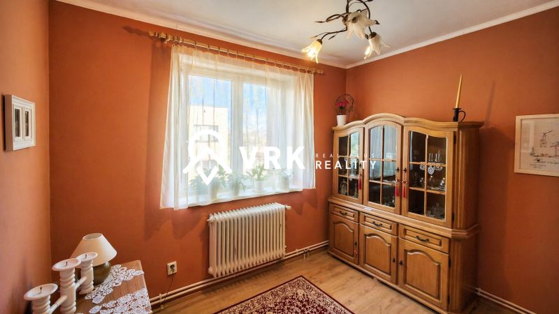 Living room in a 4-room apartment with a wooden decor floor and a wooden display cabinet.
