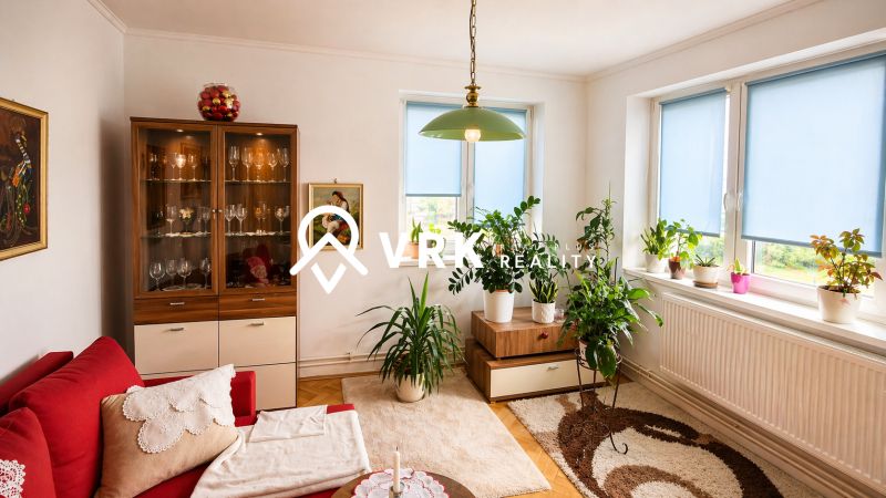 Living room with a sofa set, display cabinet, plants, and a floor with a wooden decor in a 4-room apartment.