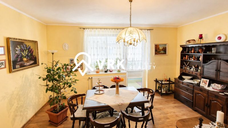Traditional dining room in a 4-room apartment with wood-patterned flooring and decorations.