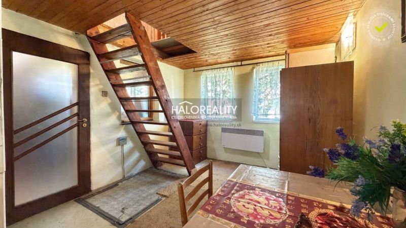 Interior with staircase, wooden ceiling, and floral decoration in the Gardens.
