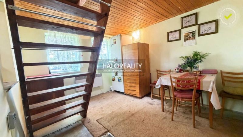 A small dining room with a staircase, wooden ceiling decor, and carpeted flooring in the Gardens.