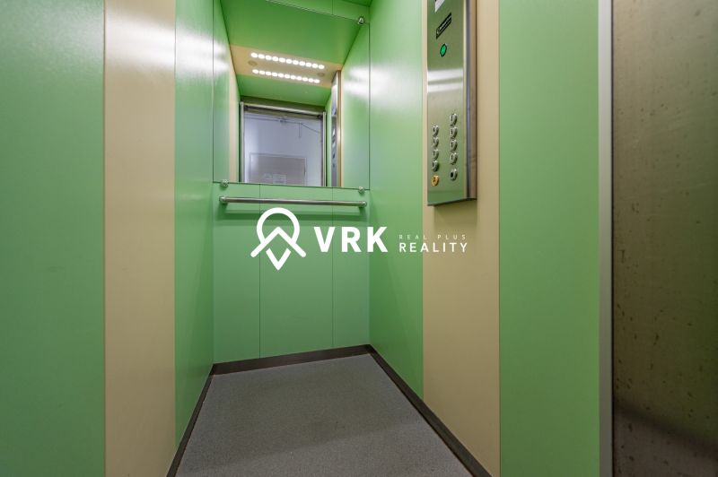 Green interior of an elevator in a 2-room apartment with a control panel.