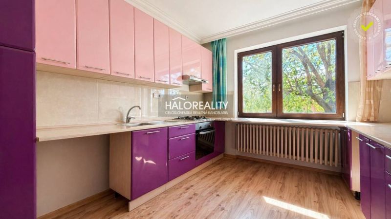 A kitchen in a family house with colorful cabinets and a wooden decor floor.