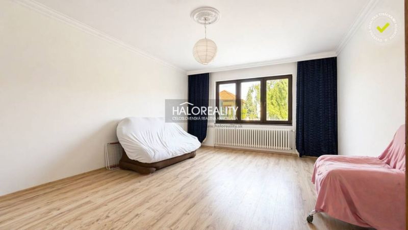 Living room of a family house with a wood-patterned floor and a large window.