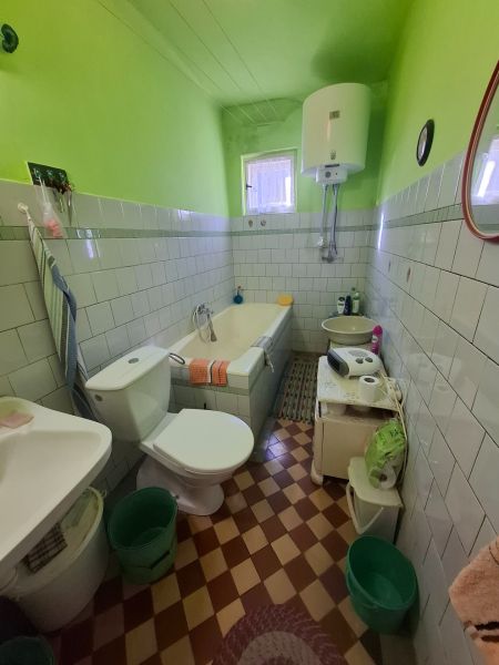 Bathroom with a bathtub, toilet, and sink in a family house with colorful walls.