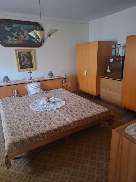 A bedroom in a family house with historical furniture and decorations of a religious nature.