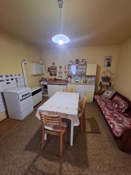 Dining room in a family house with a kitchen table, gas stove, and sofa.