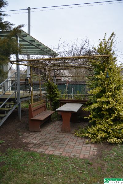 A gazebo with wooden benches and a table behind a family house in Borský Svätý Jur, Húšky.