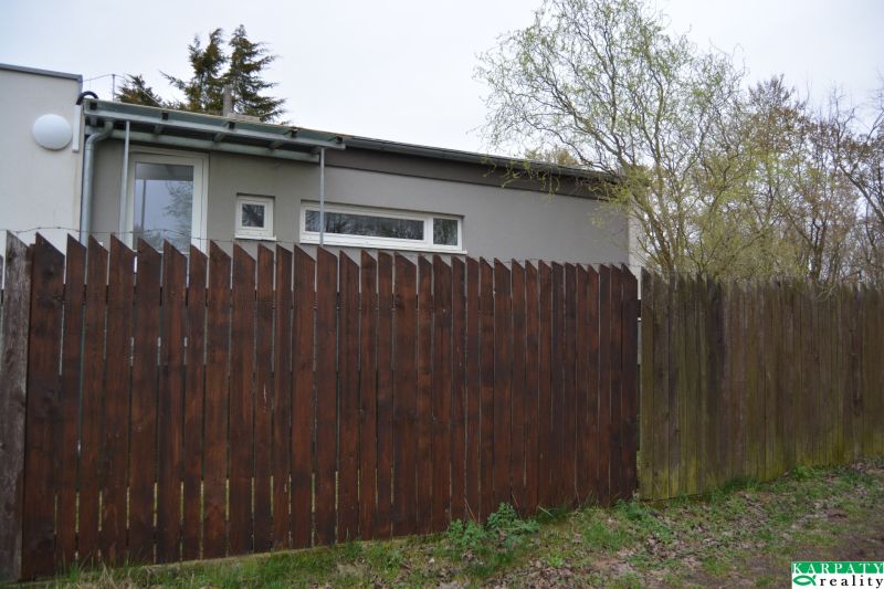 A family house on Húšky in Borský Svätý Jur with a wooden fence and trees.