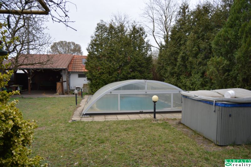 The garden of a family house on Húšky in Borský Svätý Jur with a swimming pool and a gazebo.