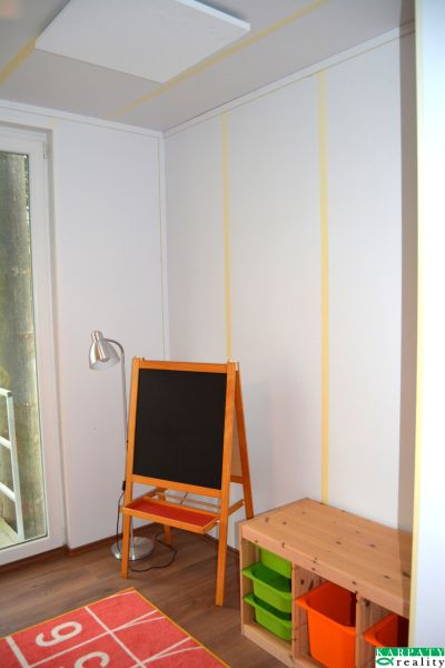 Children's corner with a blackboard in a family house, floor with wooden decor.