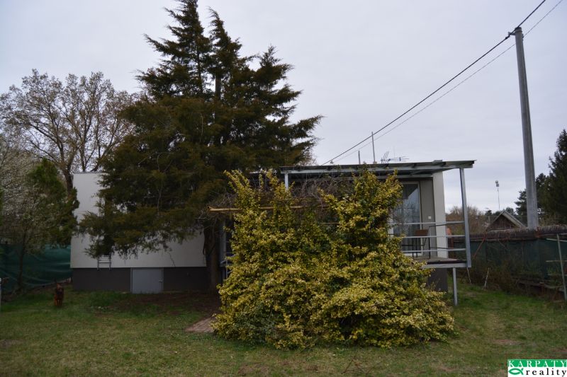 A family house on Húšky Street in Borský Svätý Jur surrounded by greenery and trees.