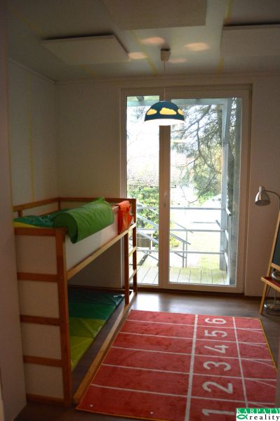 A children's room in a family house with a bunk bed and a carpet with numbers.