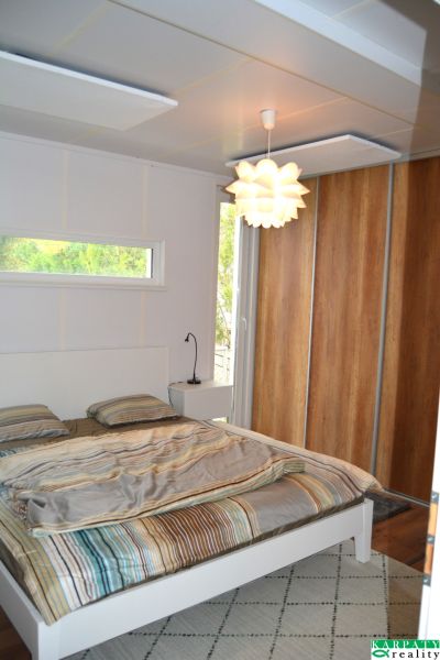 Bedroom in a family house with a bed, light fixture, and built-in wardrobe.