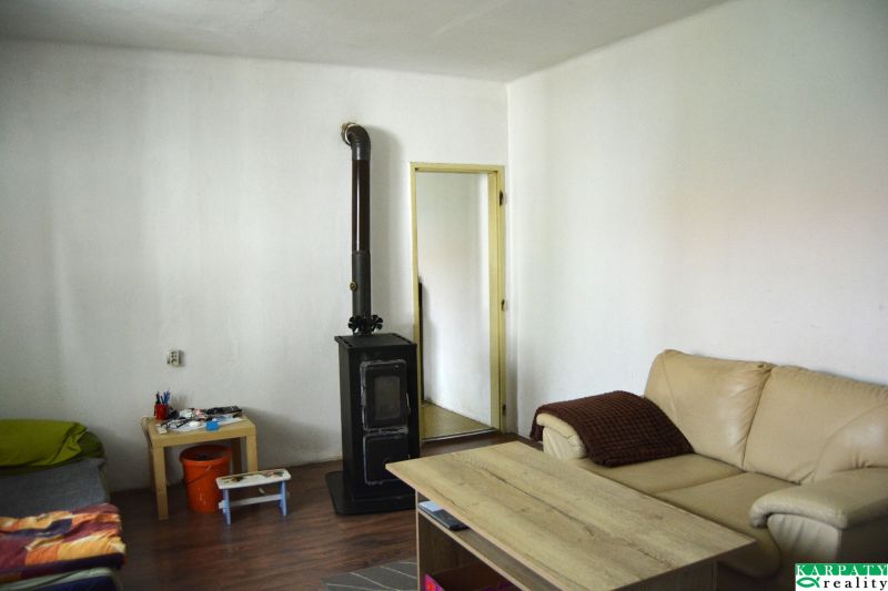 Living room with a fireplace in a family house, sofa, table, wooden decor flooring.