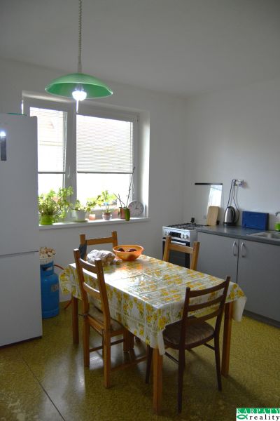 A kitchen in a family house with a dining table and houseplants on the windowsill.