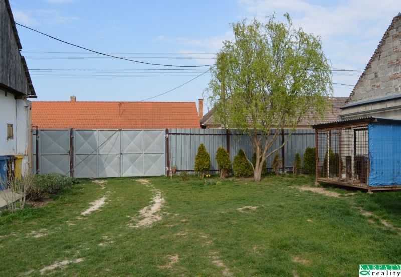 A family house in Nižná with a gate, lawn, and a tree in the garden.