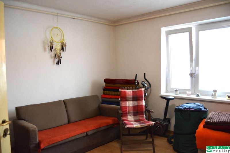 Living room in a family house with a sofa, a chair, and an exercise machine.