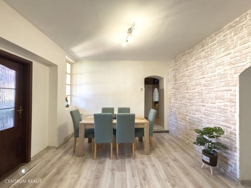 Dining area in a family house with a wooden decor floor and brick cladding.