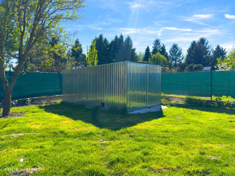 A garden with a metal shelter in Orechová Potôň near a family house.