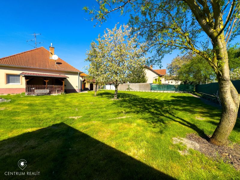 The garden of a family house in Orechová Potôň with a lawn, trees, and a gazebo.