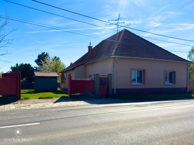 A family house in Orechová Potôň with a sloped roof and a fenced plot.