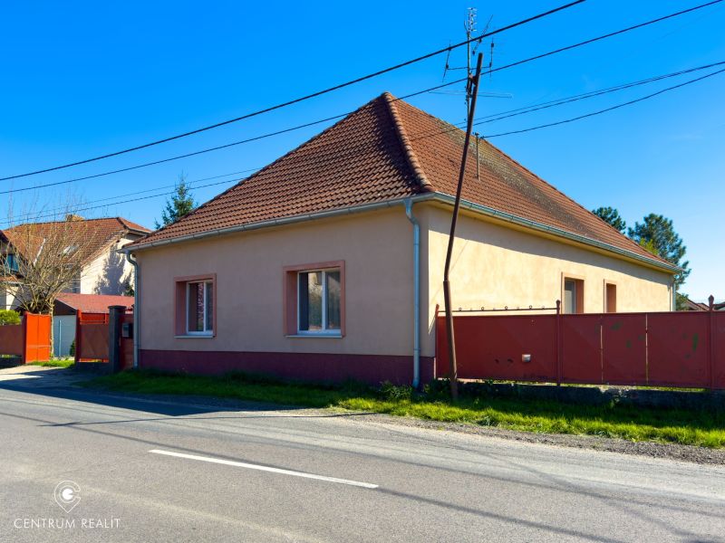 A family house in Orechová Potôň with a classic sloped roof and a red fence.