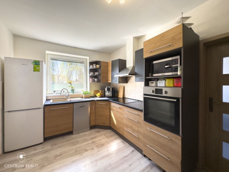 A kitchen in a family house with a wooden decor floor and modern equipment.