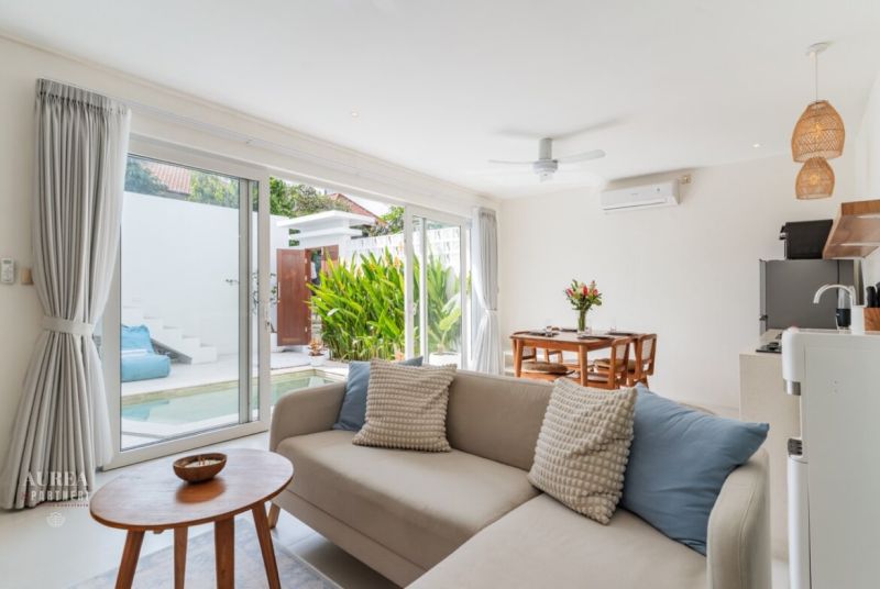 Living room in a villa with a seating area, dining table, and access to the terrace.