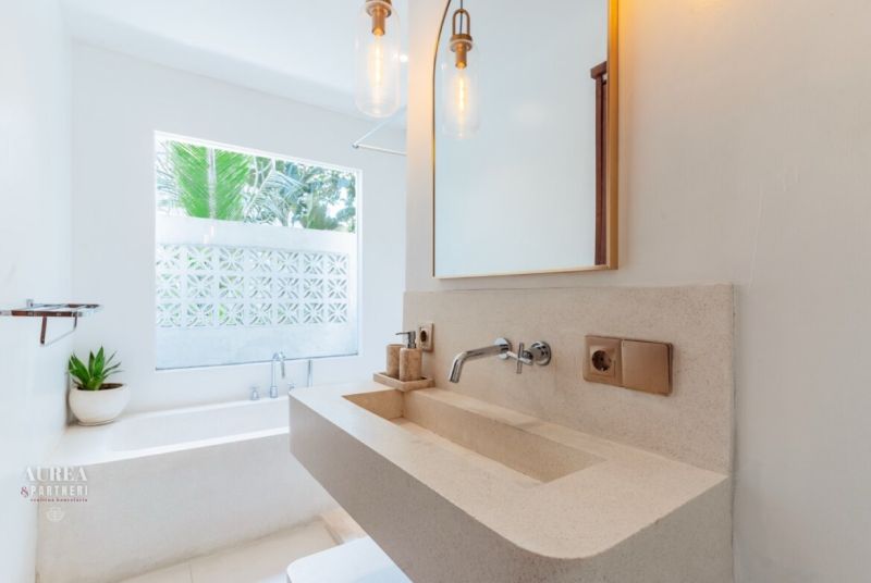 A bathroom in a villa with an elegant sink and a large window.