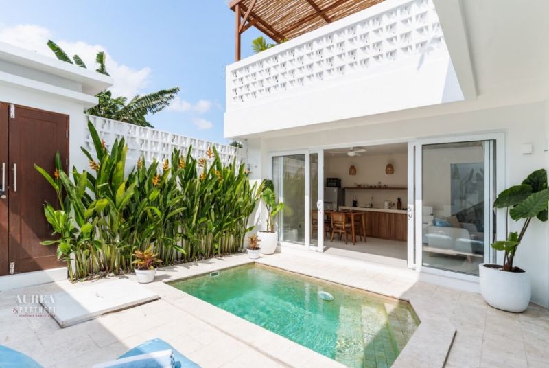 Villa in Bali with a small pool, tropical greenery, and sliding glass doors.